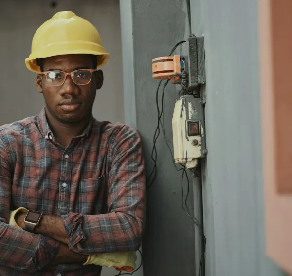 Profesional de electricidad junto a una instalación en pared